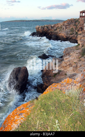 Meer große Surfwelle brechen auf Küste und Cape mit Pavillon in einem Abstand Stockfoto