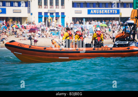 RNLI-Rettungsboot B-803 'William Hurst' und Crew in Action abseits der überfüllten Strand von Bournemouth, Dorset. VEREINIGTES KÖNIGREICH. Stockfoto