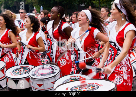 Notting Hill Carnival Parade Teenager junge schwarze, braune & weiße Mädchen Schlagzeug spielen in der berühmten Batala Brasilianer marschierendes band Stockfoto