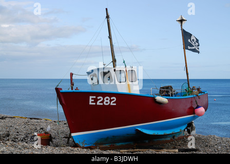 Angelboot/Fischerboot fliegen der Totenkopf am Strand von Bier, Devon, UK Stockfoto