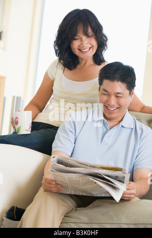 Paar entspannen mit einer Zeitung und lächelnd Stockfoto