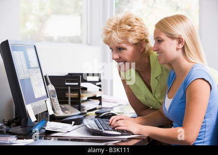 Frau und Mädchen im Büro zu Hause mit Computer lächelnd Stockfoto