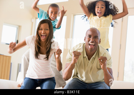 Familie im Wohnzimmer jubeln und lachen Stockfoto