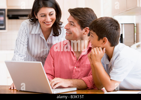 Familie in der Küche mit Laptop lächelnd Stockfoto