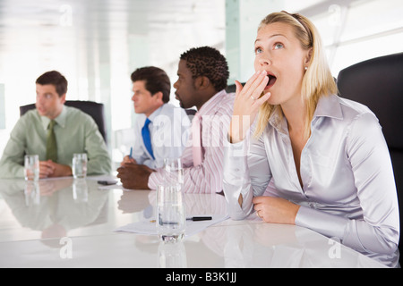 Vier Unternehmer im Sitzungssaal mit einer Geschäftsfrau Gähnen Stockfoto
