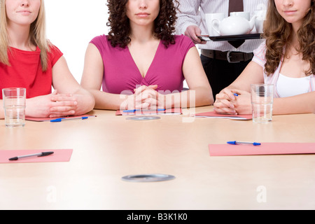 Drei Geschäftsfrauen sitzen im Sitzungssaal serviert Kaffee und Tee Stockfoto