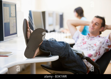 Mann im Computerraum mit Füße entspannen Stockfoto