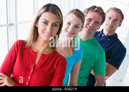 Vier Personen stehen im Flur lächelnd Stockfoto