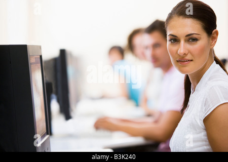 Frau im Computerraum mit Menschen im Hintergrund Stockfoto
