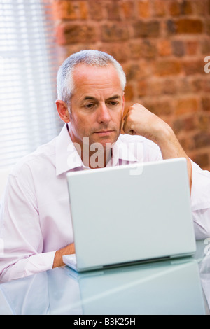 Geschäftsmann, sitzen im Büro auf laptop Stockfoto