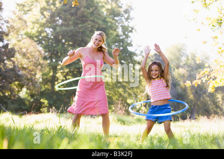 Frau und junge Mädchen mit Hula-Reifen im freien Lächeln Stockfoto