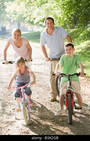 Familie auf dem Fahrrad auf Pfad lächelnd Stockfoto