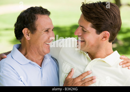 Zwei Männer stehen im freien kleben und lächelnd Stockfoto