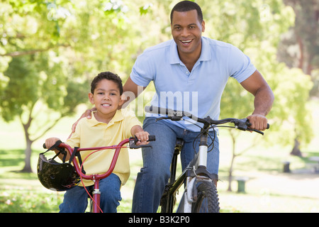 Mann und junge Junge auf dem Fahrrad im freien Lächeln Stockfoto