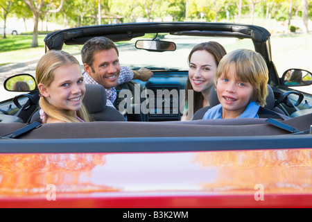 Familie im Cabrio lächelnd Stockfoto