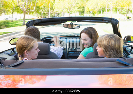 Familie im Cabrio lächelnd Stockfoto