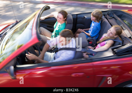 Familie im Cabrio lächelnd Stockfoto