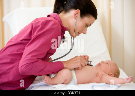 Doctor giving Checkup mit Stethoskop, Baby im Prüfungsraum Stockfoto