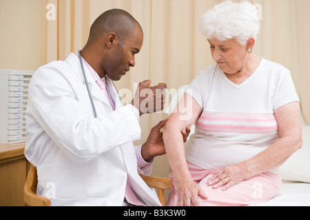 Arzt Frau im Prüfungsraum Nadel verleihen Stockfoto
