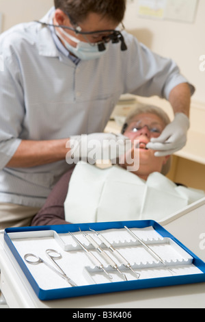 Zahnarzt im Prüfungsraum mit Frau auf Stuhl Stockfoto