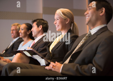 Fünf Geschäftsleute lächelnd in Präsentationsraum mit Ablagen Stockfoto