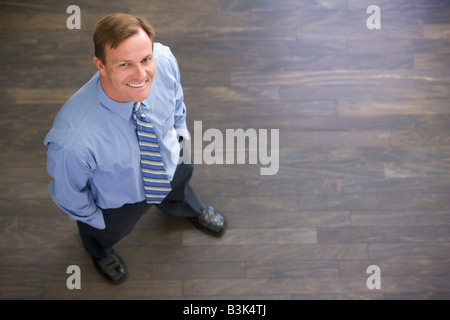 Geschäftsmann, stehen im Innenbereich lächelnd Stockfoto