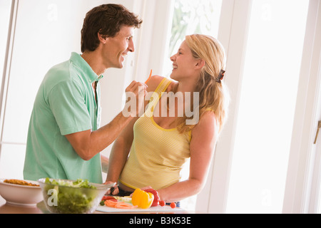 Paar in der Küche Gemüse zerschneiden und lächelnd Stockfoto