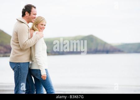 Paar steht am Strand lächelnd Stockfoto