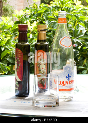 Wasser, Balsamico-Essig & Olivenöl-Flaschen auf einem Esstisch in Frankreich Stockfoto