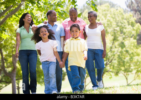 Großfamilie zu Fuß im Park Hand in Hand und lächelt Stockfoto