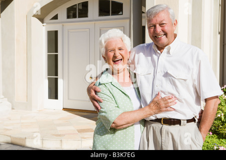 Älteres paar stehen außerhalb der eigenen Wohnung Stockfoto