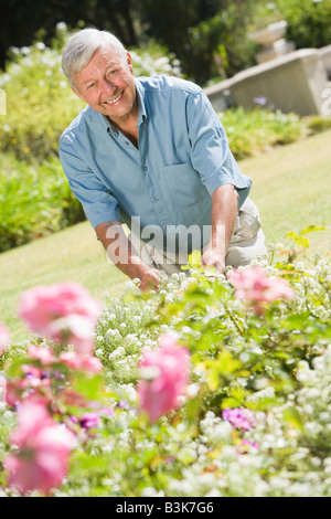 Senior woman in einem Blumengarten Stockfoto