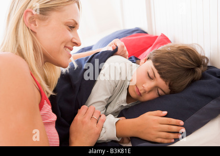 Frau Junge im Bett Lächeln aufwachen Stockfoto