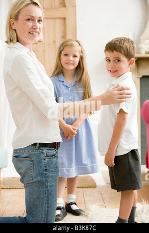 Frau im vorderen Flur mit zwei kleinen Kindern, die lächelnd Stockfoto