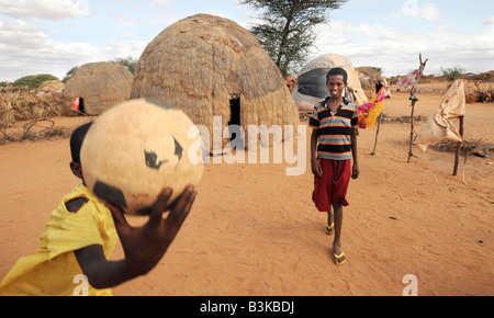 Im Leerlauf Abdi Lahi 12 halten Ball und Mohammed Nor Abdi in Belet Amin (Binnenvertriebene) Flüchtlingslager, Somalia. Stockfoto