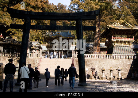Touristen gehen Sie unter einem Tori Tor an der Toshogu-Schrein des Shogun Tokugawa Ieyasu in Nikko, Japan. Stockfoto
