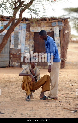 Abdiwah Hassan Abdi 17, seine Haare schneiden durch Mowhid Mahmod Moge Barbier in Belet Amin ein Lager für Vertriebene Somalis Stockfoto