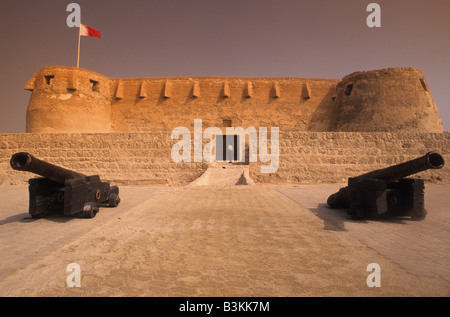 Naher Osten, das Königreich Bahrain (Arabisch: Mamlakat al-Baḥrayn), Fußgänger, die außerhalb der Festung Arad Muharraq Insel. Stockfoto