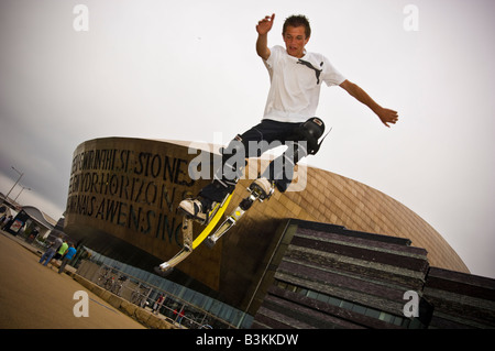 Junger Mann auf bouncy Pogo Stelzen Bockers tun akrobatische Stunts außerhalb des Wales Millennium Centre Cardiff Bay UK Stockfoto