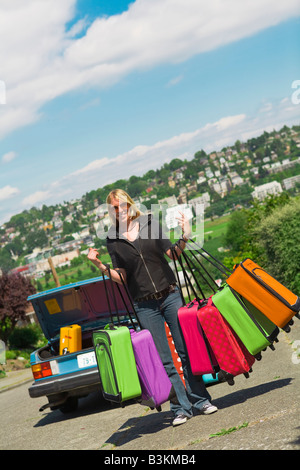 Frau, die viele bunte Koffer Stockfoto