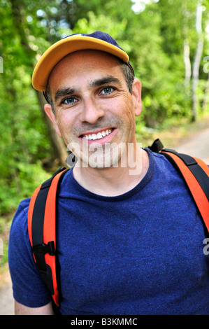 Porträt der glückliche Mann mittleren Alters auf einem Waldweg Stockfoto