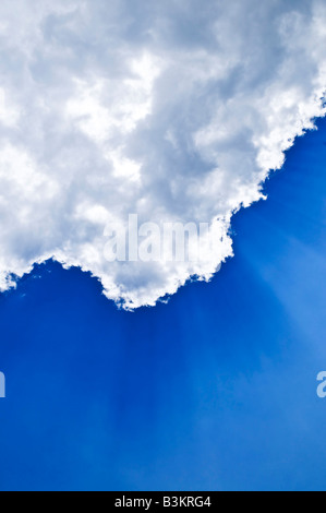 Blauer Himmel mit Sonnenstrahlen hinter den Wolken scheint Stockfoto
