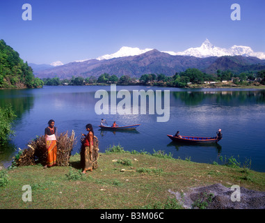 Nepalesische Land Frauen mit großen Bündeln von Brennholz an den Ufern des Sees Phewa Tal von Fishtail Berg übersehen Stockfoto