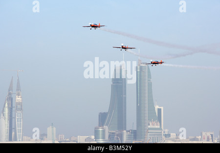 Die Kunstflugstaffel klingen in den Himmel über Bahrain mit der Skyline von Manama im Hintergrund anzeigen. Stockfoto
