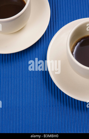 Zwei Kaffeetassen auf blauem Hintergrund isoliert Stockfoto