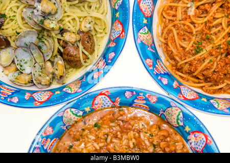 Tris von italienischer Pasta und Reis-Spaghetti mit Venusmuscheln Spaghetti mit mix Meeresfrüchte Reis mit Tintenfisch Stockfoto