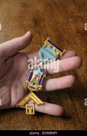 Eine alte, gold, Freimaurer Medaille aus den 1930er Jahren mit Band und Kompass und quadratischen Motiv sichtbar. Stockfoto