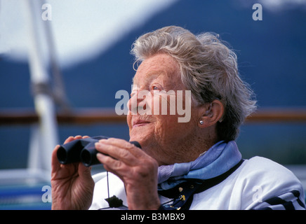Porträt der Frau Senioren mit dem Fernglas einen Tag der Kreuzfahrt auf einem Kreuzfahrtschiff in der freien Natur zu genießen Stockfoto