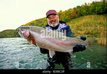 Südwesten ALASKA lächelnd Fischer hält Trophäe Regenbogenforelle fing in der Naknek River in der Nähe von King Salmon Stockfoto