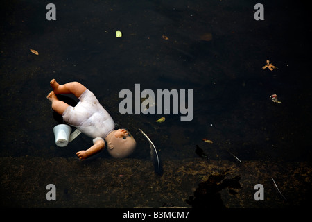 Kinder-Puppe in Wasser mit Müll entsorgt Stockfoto